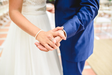 Boyfriends on their wedding day holding hands romantically.