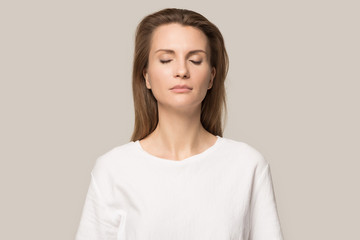 Calm mindful woman with closed eyes breathing deep, no stress
