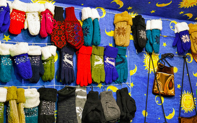 Colorful warm gloves and socks at the Christmas Market in Vilnius, Lithuania. Clothes. Wool mittens on stalls in winter. Street Xmas and holiday fair. Advent Decoration with Craft on Bazaar