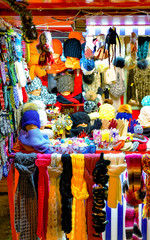 Knitted goods displayed on a Christmas market stall. Old Town of Riga, Latvia. Wool mittens, gloves, socks with hats in winter. Street Xmas and holiday fair in European city. Advent Crafts on Bazaar