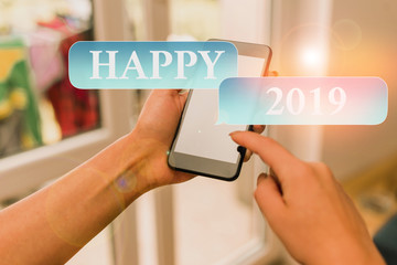 Text sign showing Happy 2019. Business photo text feeling showing or causing pleasure or satisfaction for 2019 woman using smartphone office supplies technological devices inside home