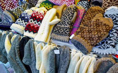 Colorful warm gloves and socks at the Christmas Market in Riga, Latvia. Clothes. Wool mittens on stalls in winter. Street Xmas and holiday fair in European town. Advent Decoration with Craft on Bazaar