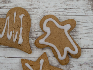 Gingerbread cookies with sugar icing on wooden background