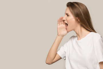 Attractive young woman shouting at copy space, making announcement