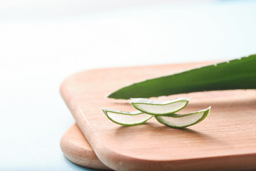 aloe vera slices, aloe leaf on bamboo cutting surface, isolated on white background