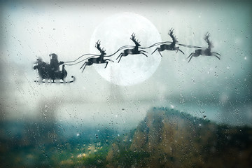Santa flying on sky over over the mountains. Marry Christmas and happy holiday.