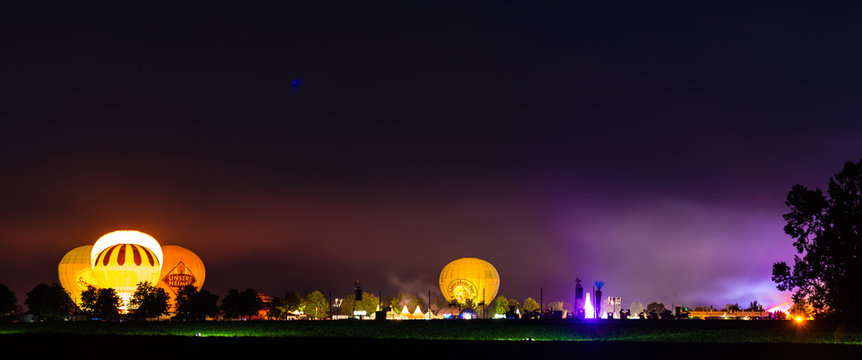 hot air ballons and tents in the evening during a festival