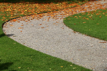 Obraz premium Kiesweg durch einen Park im Herbst