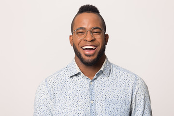 Head shot portrait laughing African American man in glasses isolated
