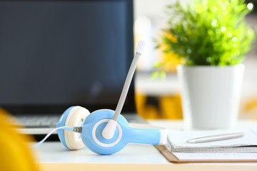 Empty remote office workplace with laptop and headset