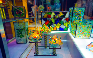Fototapeta premium Street glass lamps candleholders with candle at Christmas Market at Winter Riga, Latvia. Advent Fair Decoration and Stalls with Crafts Items on the Bazaar. Latvian street Xmas and holiday