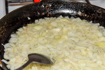 Finely chopped onion fried in a pan.