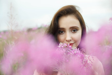 Beautiful girl in a field of lilac flowers.