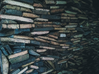 Stacked sawn boards from the warehouse. Harvested boards for heating in winter. Wooden lumber stacked.