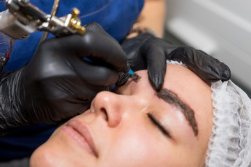 Cosmetic procedures for the treatment of eyebrows. Microblading in the beauty salon. Professional...