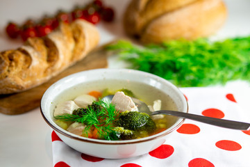 Homemade chicken vegetable soup, overhead, close-up view on a white background. bowl of fresh...