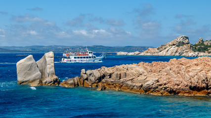 Cruise boat with tourists in the sea near rocky coast of Sardinia, the Maddalena archipelago. © Telly