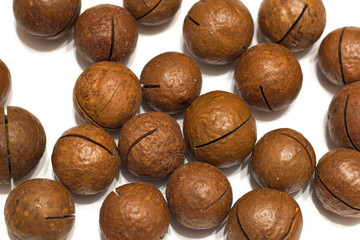 Shelled and unshelled macadamia nuts on white background