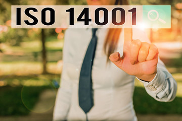 Writing note showing Iso 14001. Business concept for a family of standards related to environmental analysisagement Handsome business girl pointing with finger into empty space