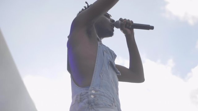 Black rapper in overalls on stage