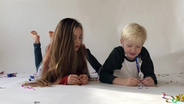 Girl and boy talking, 7 years old, girl with long hair listening to boy with white hair, dreaming together, good friends, lying on white floor, white background