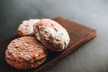 Homemade delicious chocolate cookies with powdered sugar on dark background