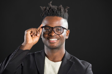 handsome African man in a suit with glasses on a black background