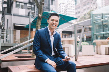Joyful entrepreneur sitting on wooden bench