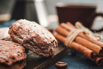 Homemade bakery, chocolate cookies with powdered sugar, cinnamon sticks, close-up view
