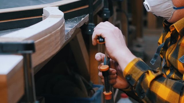 Carpentry industry - a man woodworker measuring the detail width for the next processing