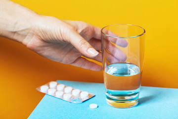Timely medication is a guarantee of the health of the body. A hand reaches for a glass of water to...