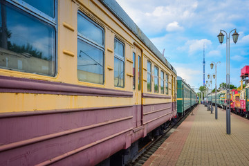 Fototapeta na wymiar yellow-red train carriage, old carriage on the platform, side view of the train carriage, windows on the train