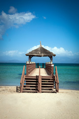 Tropical beach with wooden footbridge and summer holiday background