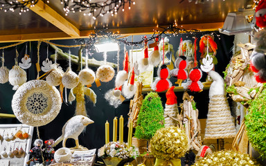 Christmas Handmade souvenirs Decorations on Christmas Market at Riga, Latvia. Advent Fair, and Stalls with Crafts Items in Bazaar. Night street Xmas and holiday fair in European city or town, December - obrazy, fototapety, plakaty