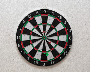 Dartboard with darts on the wall.