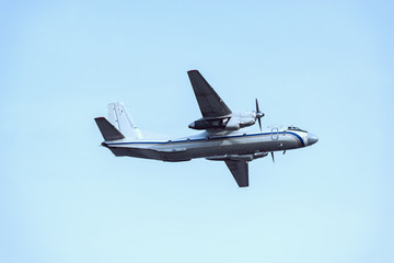 Passenger retro plane in the clear sky at evening time.