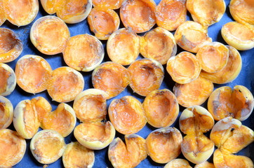 Sliced ​​sliced ​​apricot fruits on a metal sheet.
