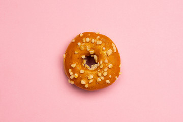 Sweet caramel donut on pink background isolated flat lay