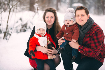 Fototapeta premium portrait of a stylish family having a good time in the winter forest. decorated place to relax.