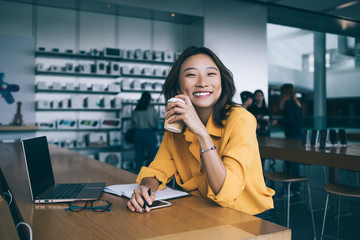 Smiling female freelancer having coffee break