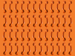 Seamless pattern of an orange retro style telephone
