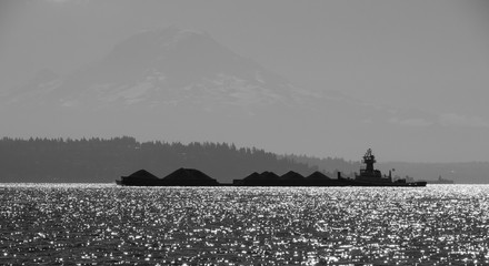 Tug pushing barge in Puget Sound with Mount Rainier in background