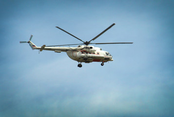 Fototapeta na wymiar Helicopter flying against the blue sky