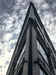 Corner of a building against a cool blue sky and clouds background