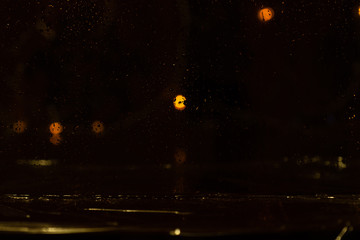 Obraz premium Blur rain drop window street evening night light bokeh abstract background