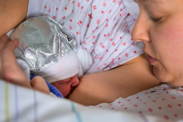 First breastfeeding - mother with her newborn child.