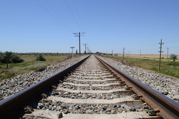 Fototapeta na wymiar Single-track railway goes along the steppe.