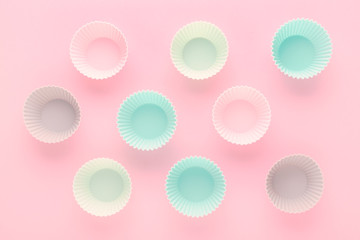 silikone forms for baking muffins and cupcakes on pastel pink background