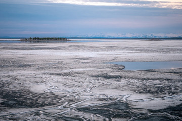 Stones on the White Sea coast at sunset. Frozen water, summer, white nights.