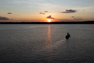 Fototapeta premium Silhouette of boat on the river at sunset